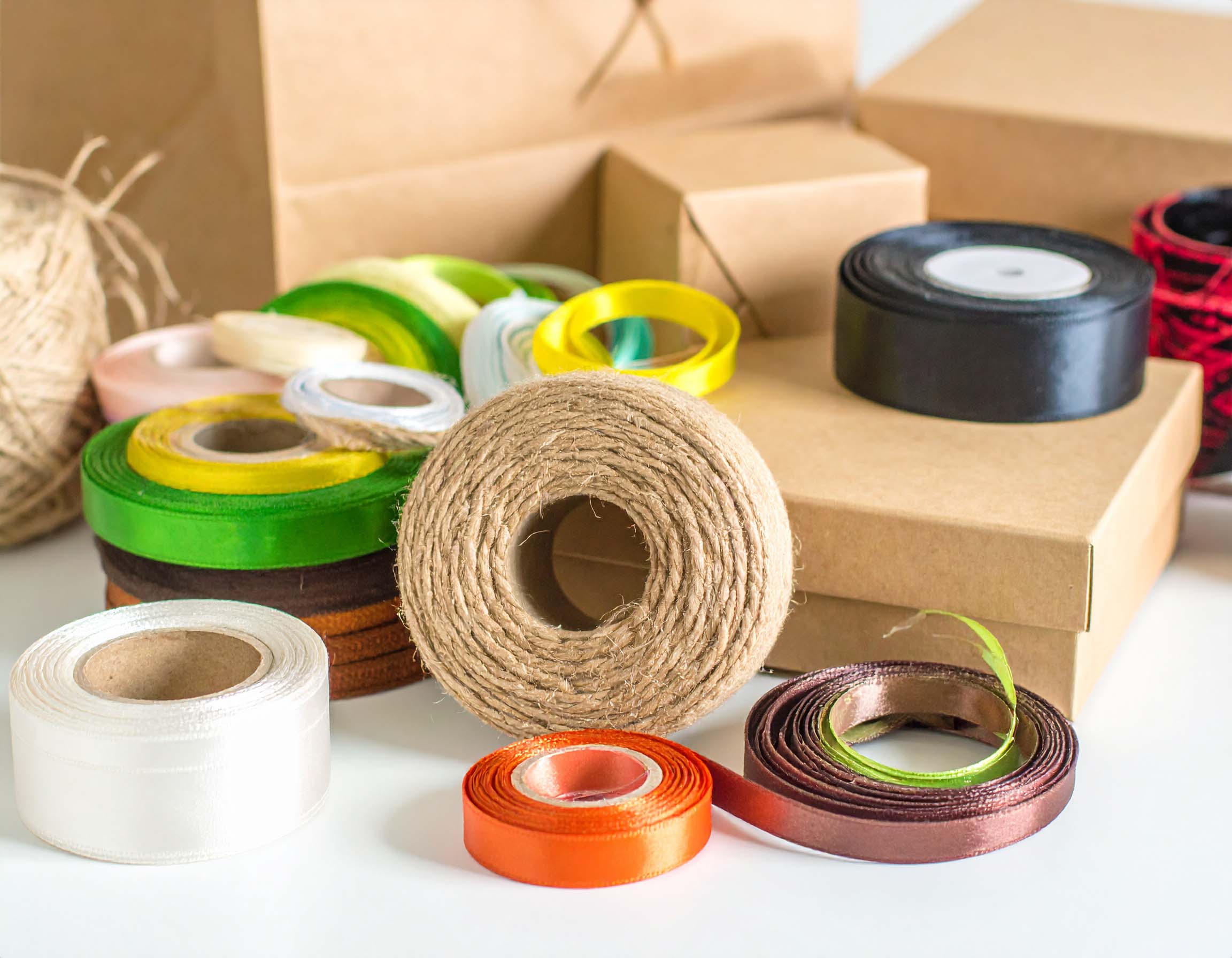 Composizione elegante e colorata di corde e nastri per packaging, disposti artisticamente